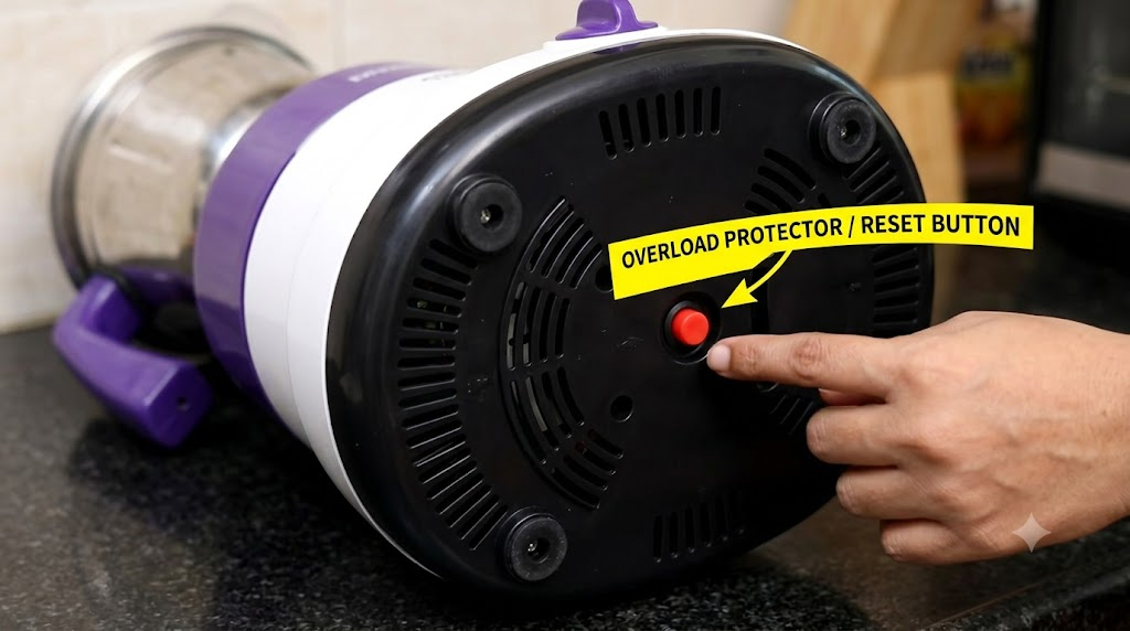 Overload protector reset button located on the bottom of a mixer grinder